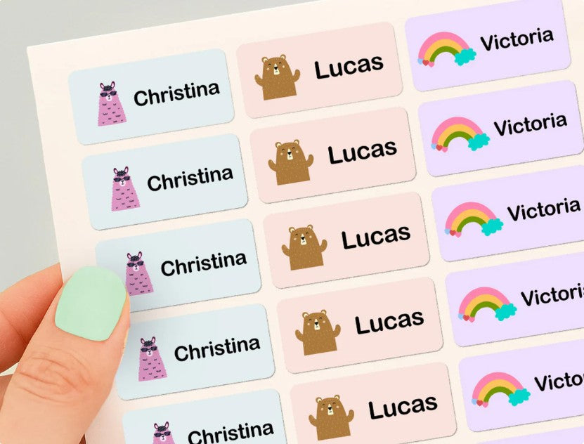 Hand som håller ett tryckt ark med färgglada namnlappar för Christina, Lucas och Victoria